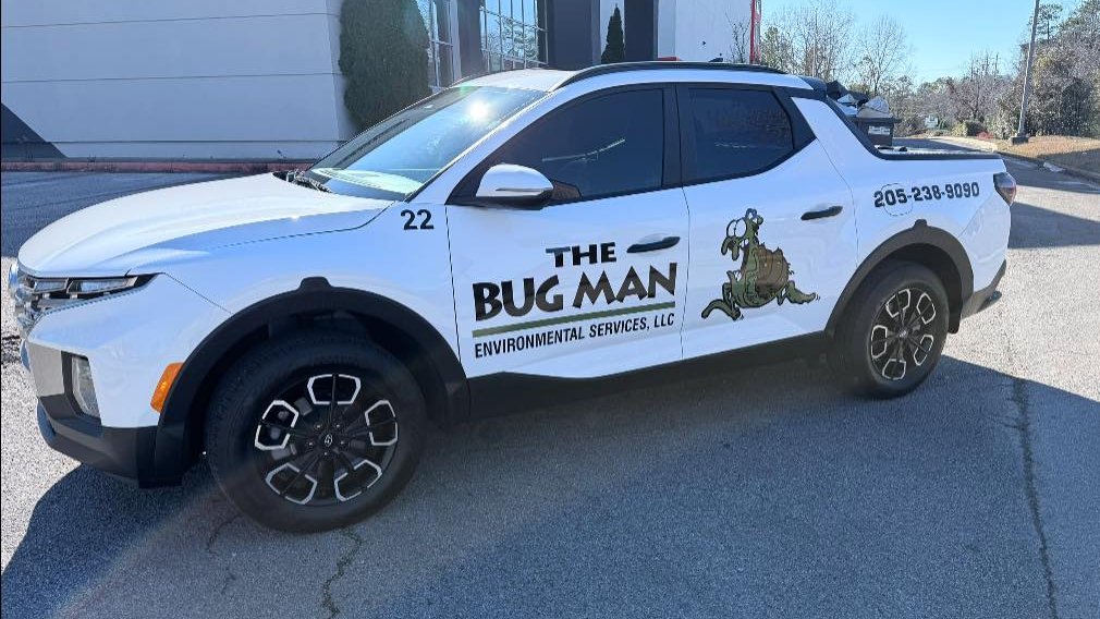 The Bug Man service truck with the cartoon bug mascot, side view